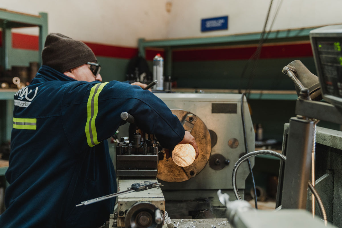 Machinist focused on operating a lathe in a busy workshop. Image by ClaudioMeloni@pexels.com