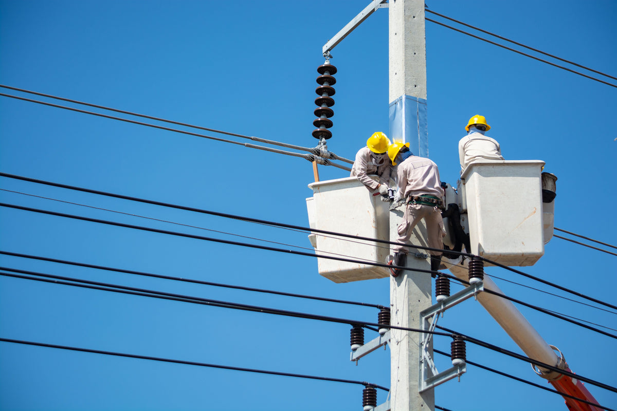 Electricians work on power lines. Image by ThampaponOtavorn@pexels.com